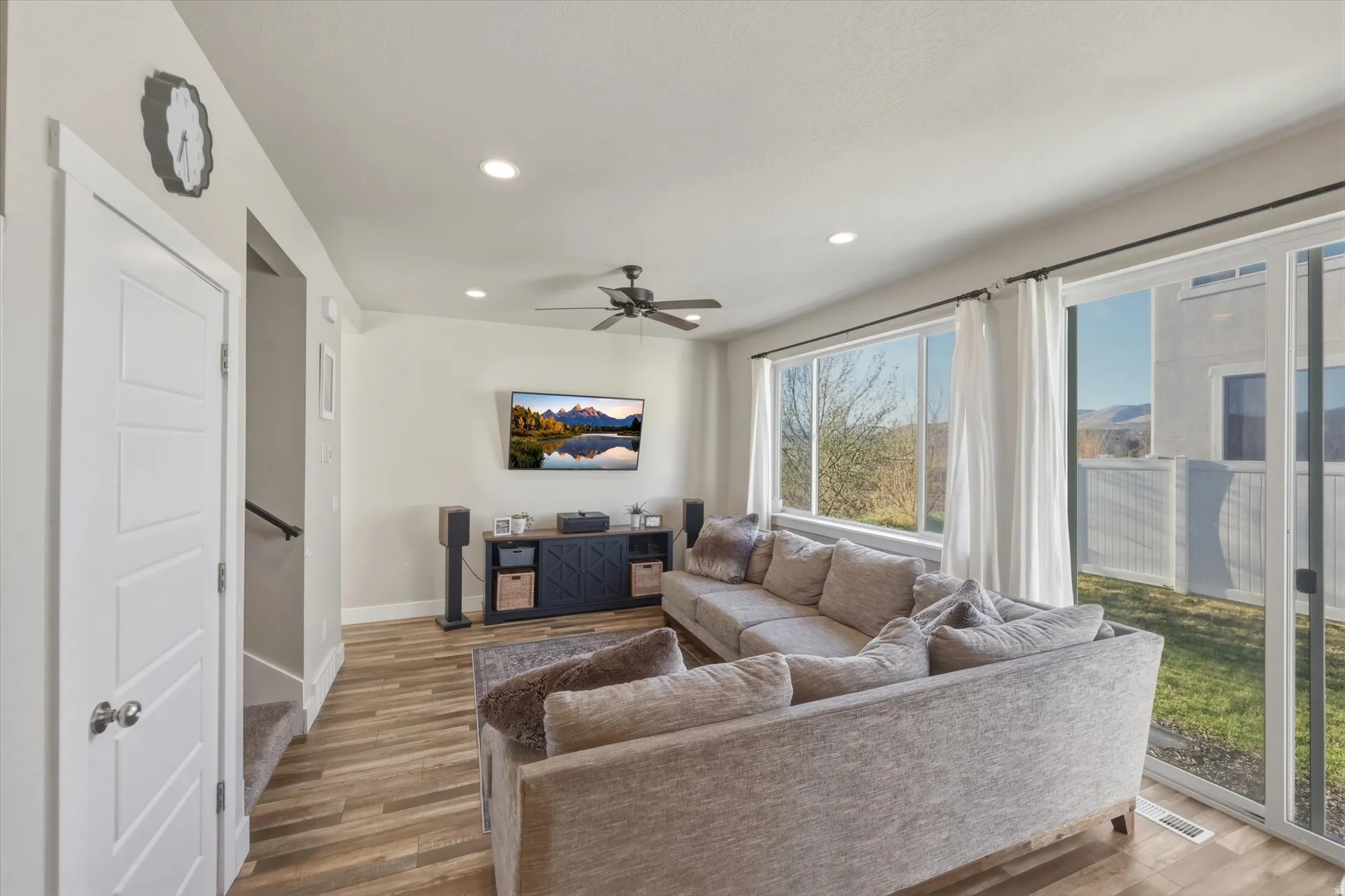 Living area with recessed lighting, wood finished floors, and ceiling fan