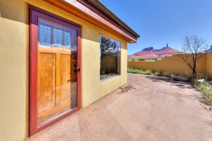 View of exterior entry featuring stucco siding, a patio area, and a mountain view
