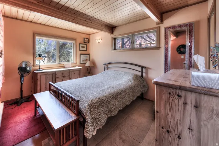 Bedroom with a wooden ceiling with exposed beams