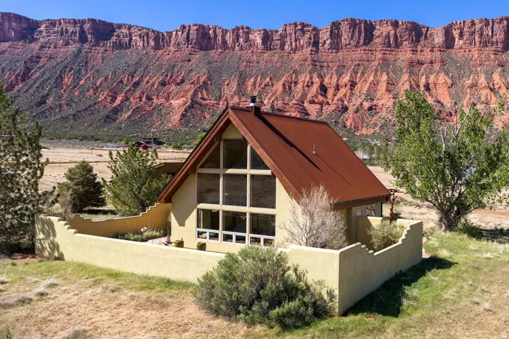 Back of house featuring a mountain view and stucco siding