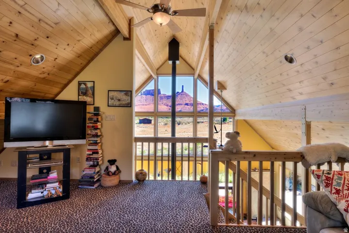 Carpeted living area with a wood ceiling with exposed beams and a mountain view