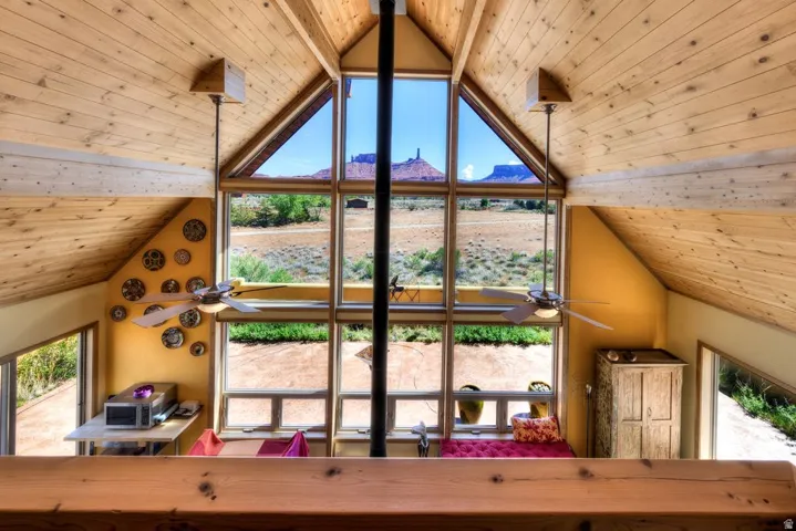 Detailed view of wooden ceiling, a mountainous background, and a ceiling fan