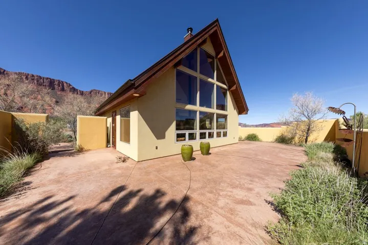 Rear view of property featuring a chimney, stucco siding, a patio, and a mountain view