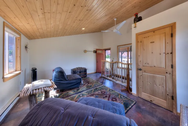 Living room with a ceiling fan, concrete floors, a vaulted wood ceiling, and recessed lighting