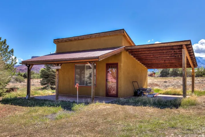 View of front of property with a metal roof and a front lawn