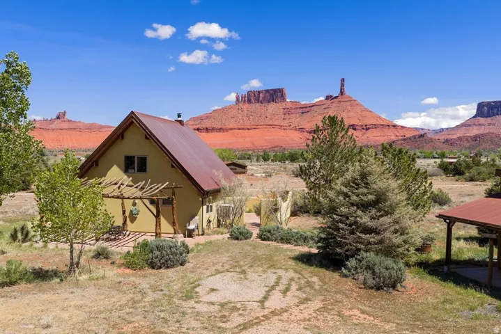 Back of property with a mountain view, stucco siding, and a metal roof