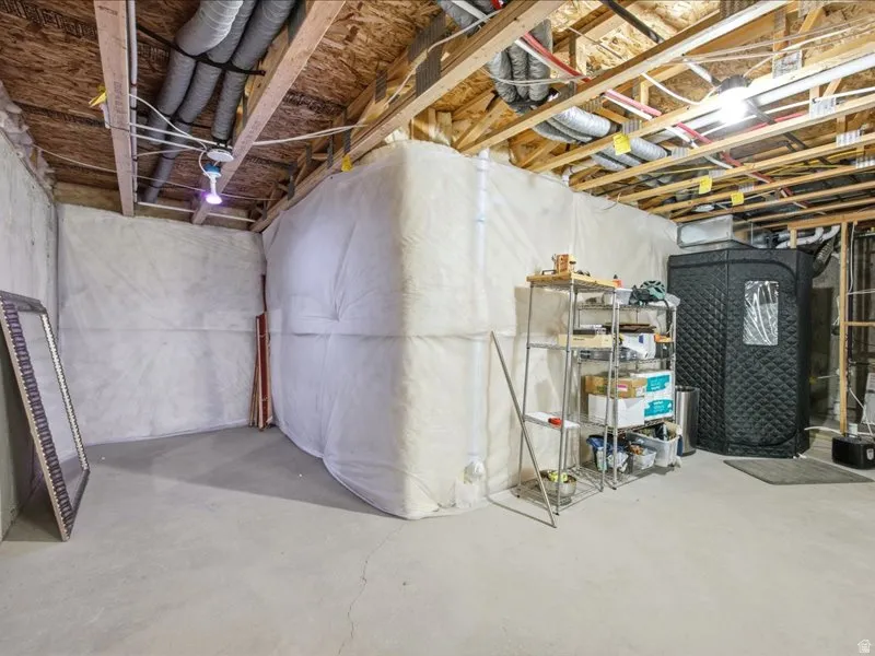 View of unfinished basement plumbed for bathroom