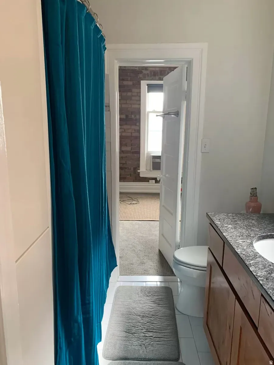 Bathroom featuring vanity, light tile patterned flooring, and a shower with curtain