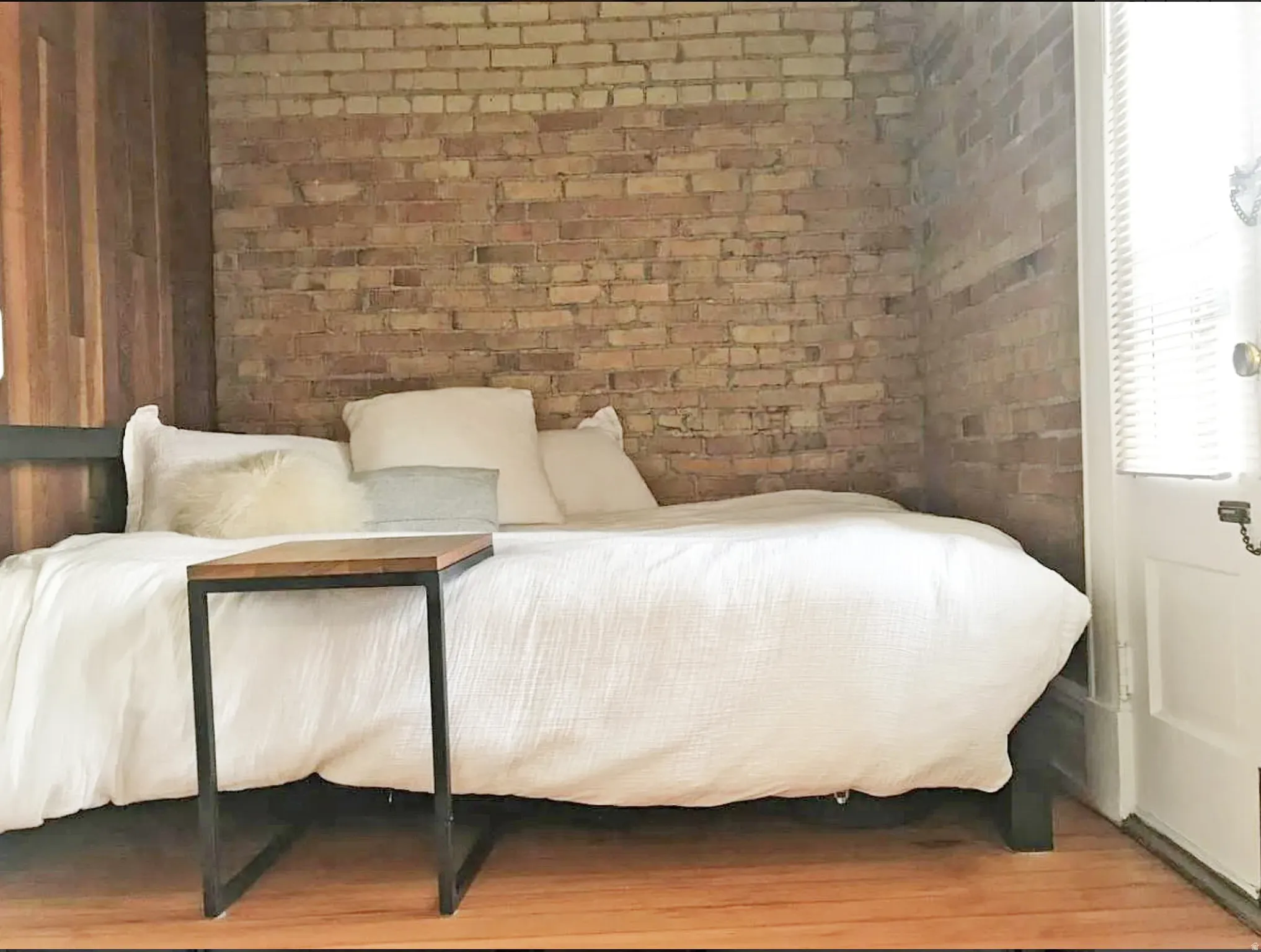 Bedroom with brick wall and wood finished floors