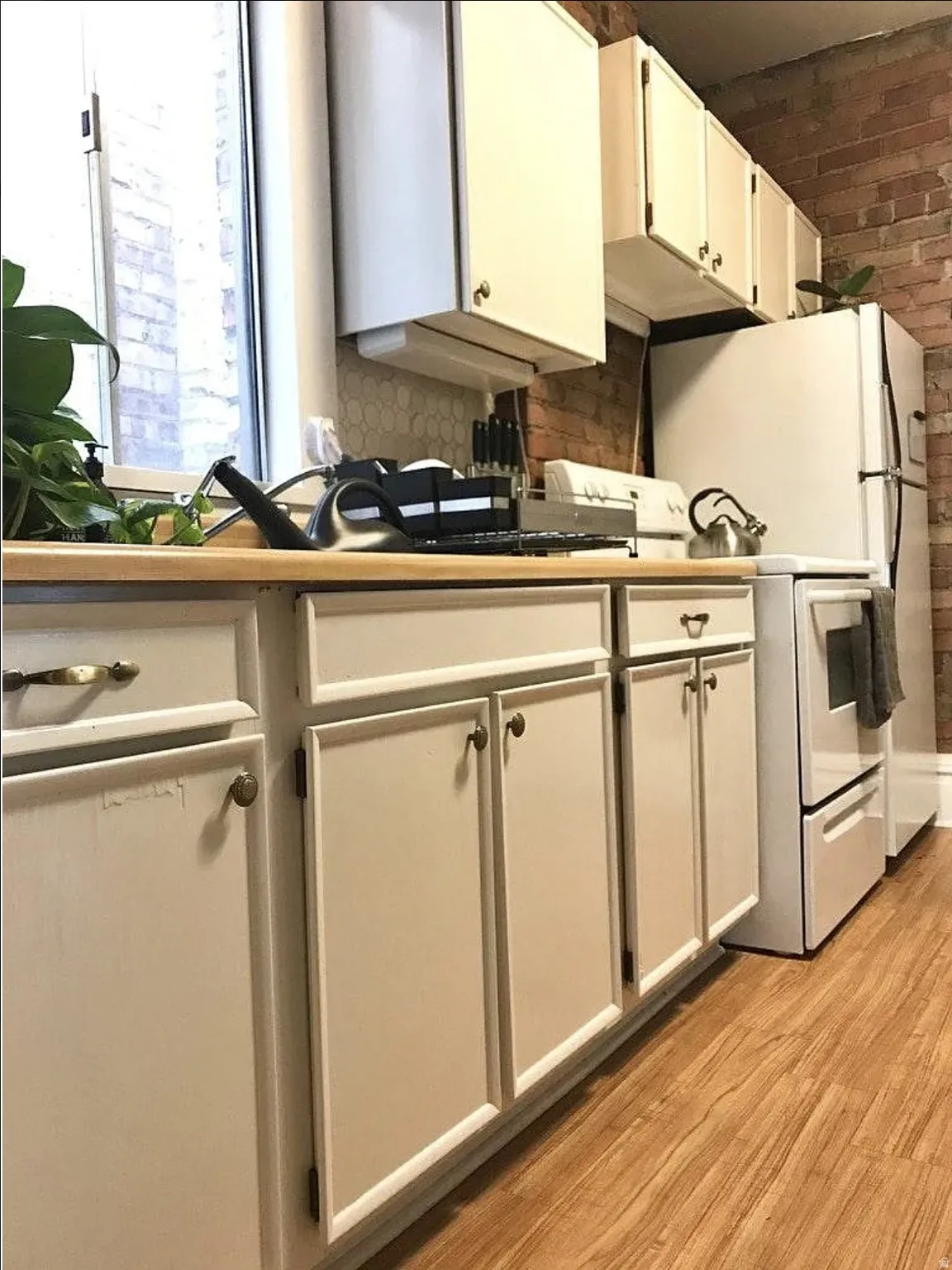 Kitchen featuring white range with electric cooktop, light wood-type flooring, white cabinetry, and light countertops