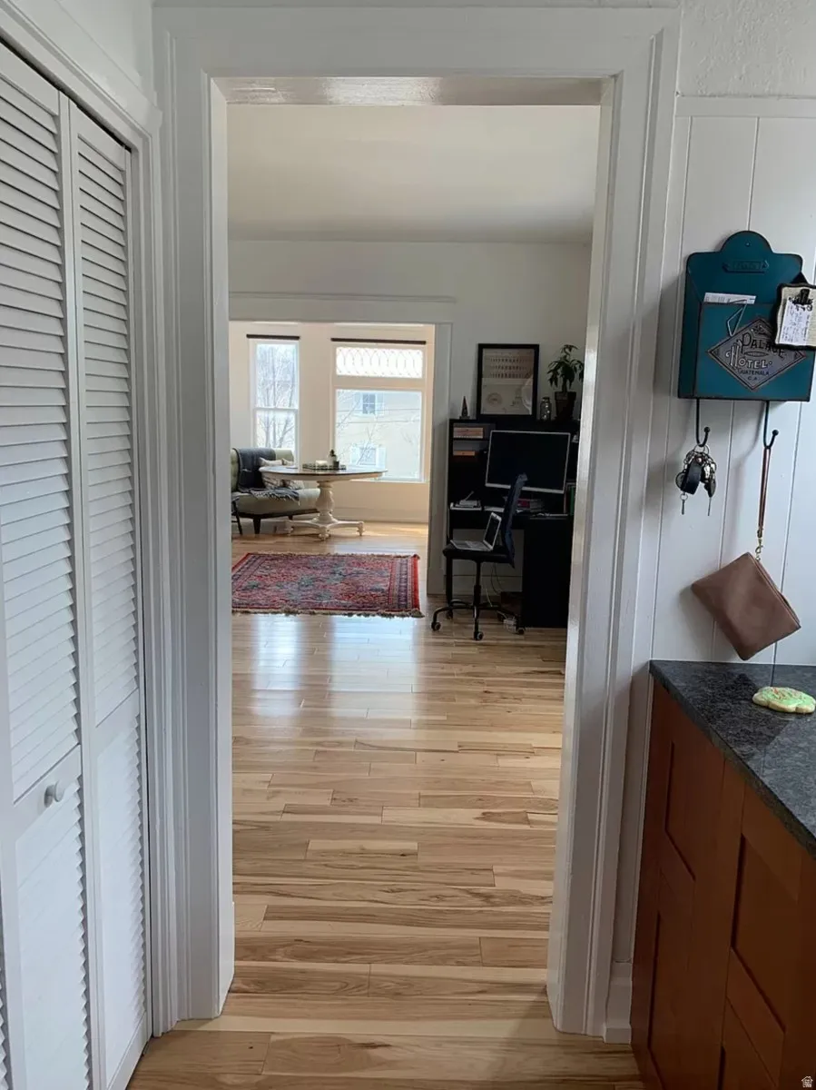 Hallway with an office area and light wood-style flooring