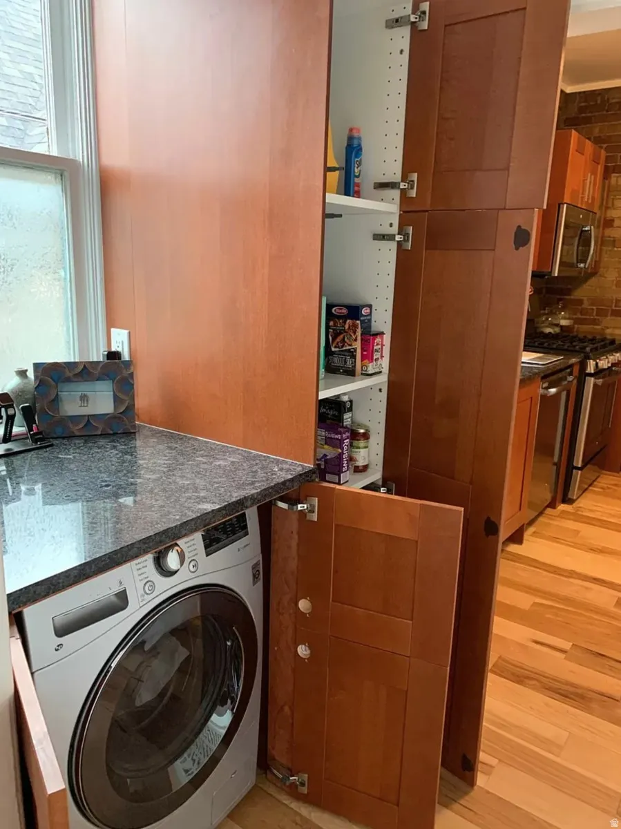 Laundry area with washer / clothes dryer and light wood-type flooring