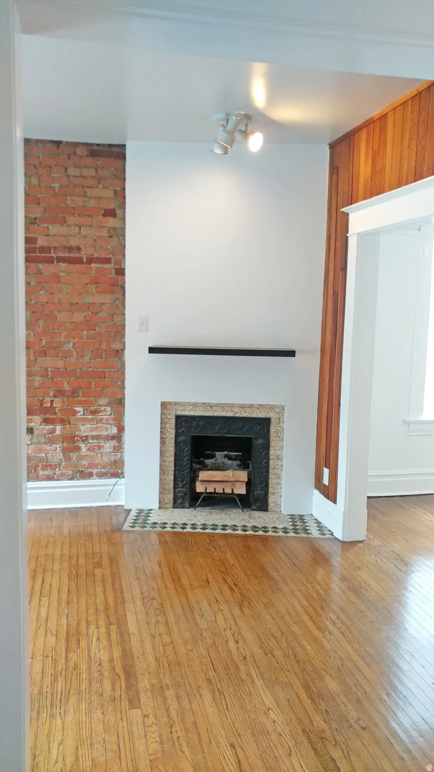 Unfurnished living room featuring light wood-type flooring and a fireplace