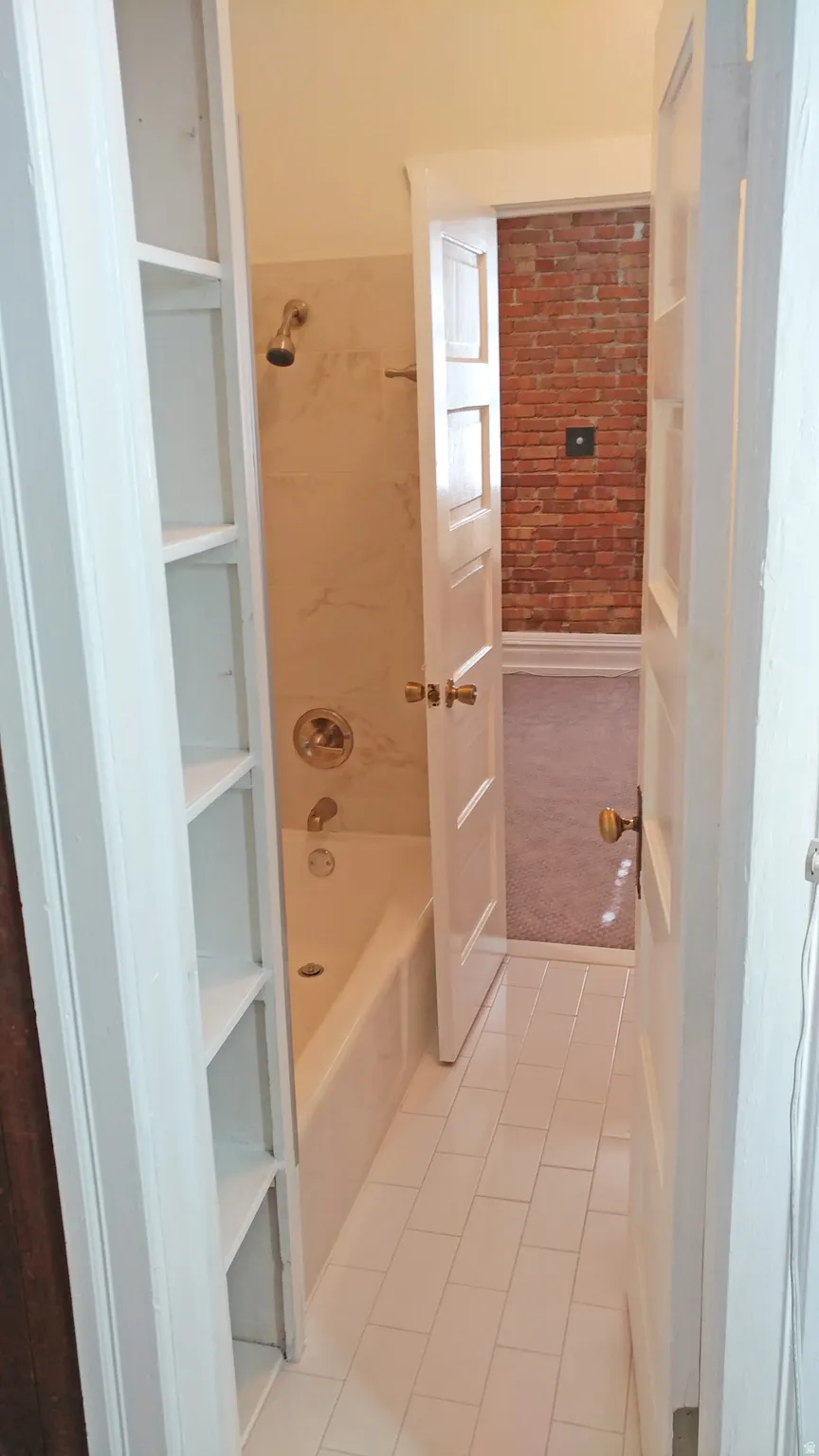 Full bathroom with light tile patterned floors, a closet, and shower / bath combination