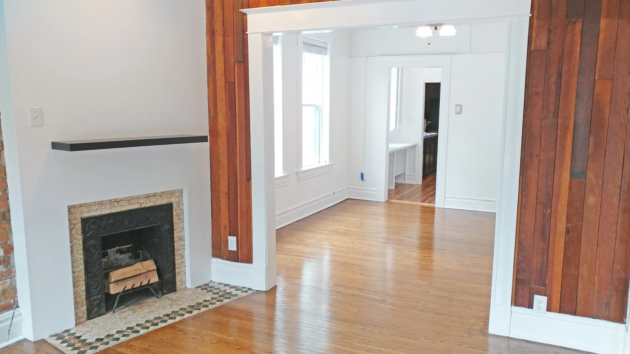 Unfurnished living room featuring light wood-type flooring and a fireplace