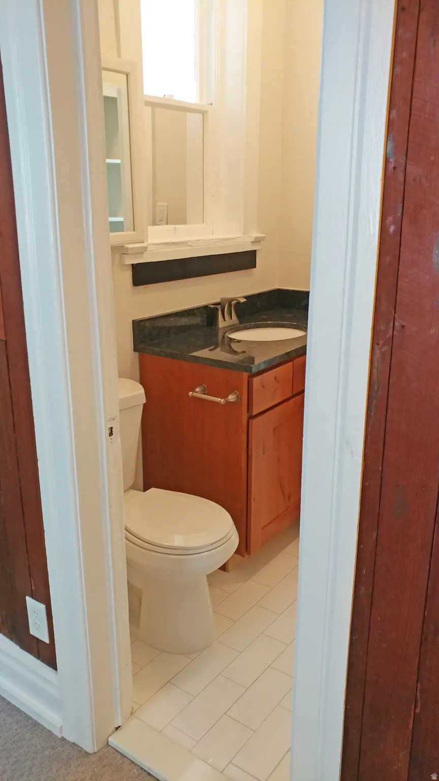 Half bath with vanity and light tile patterned flooring