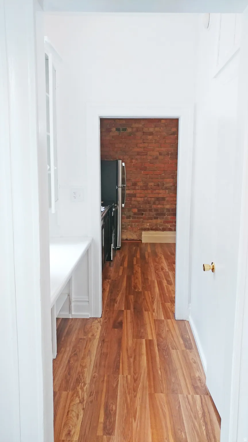 Hall with light wood-style floors and baseboards