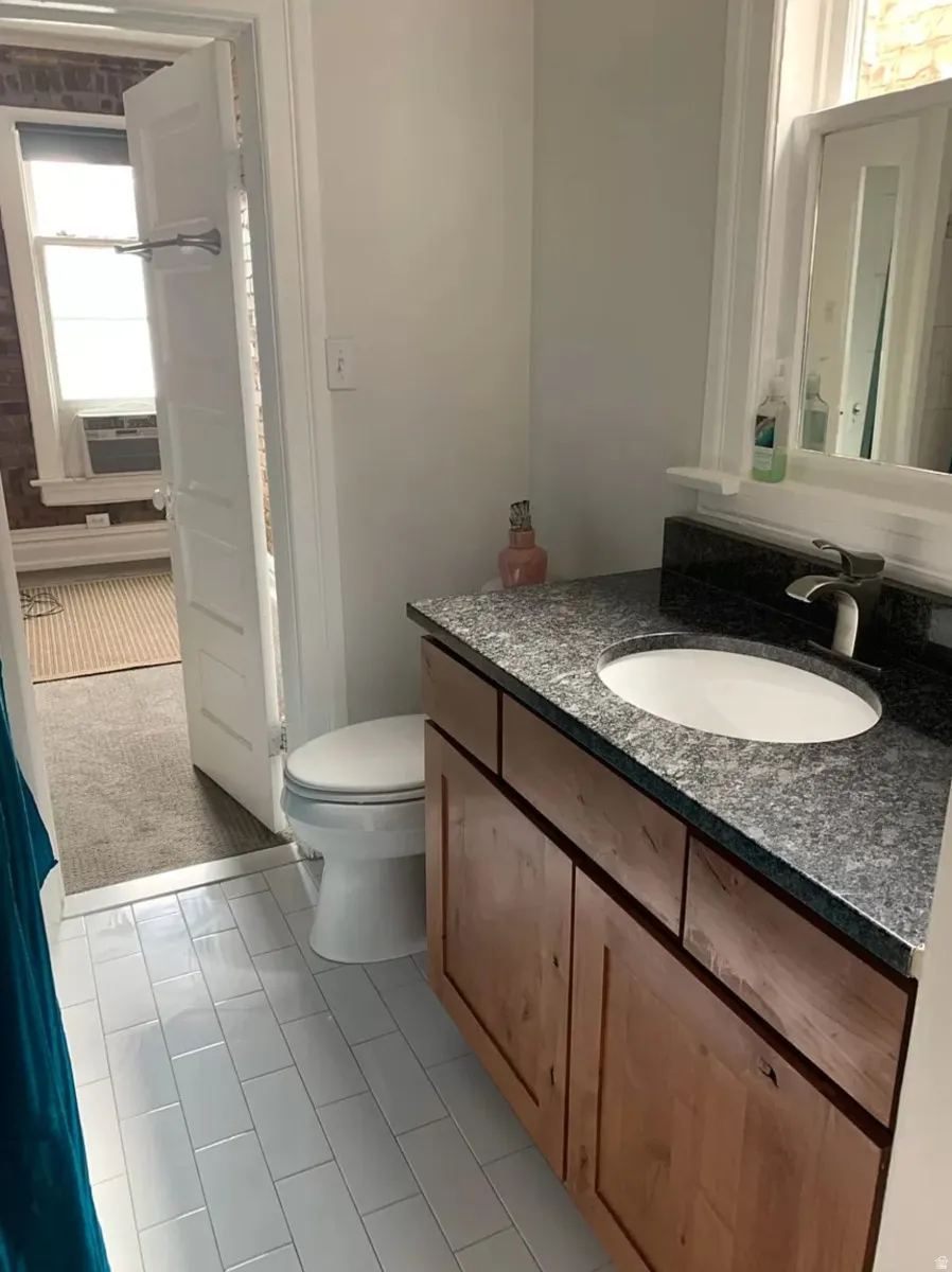 Bathroom featuring vanity, light carpet, and light tile patterned flooring