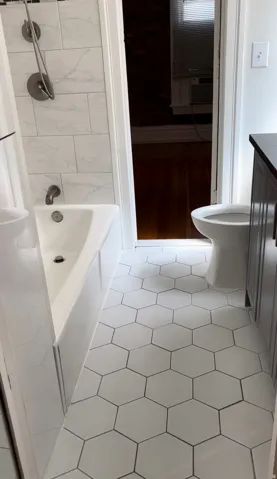 Full bath with vanity, light tile patterned flooring, and shower / tub combination