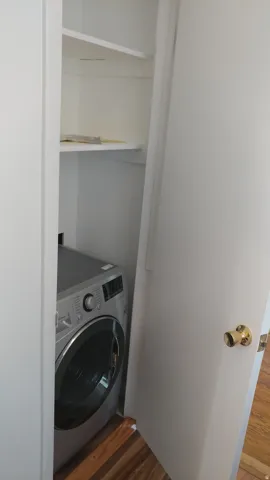 Laundry area featuring washer / dryer and dark wood-type flooring