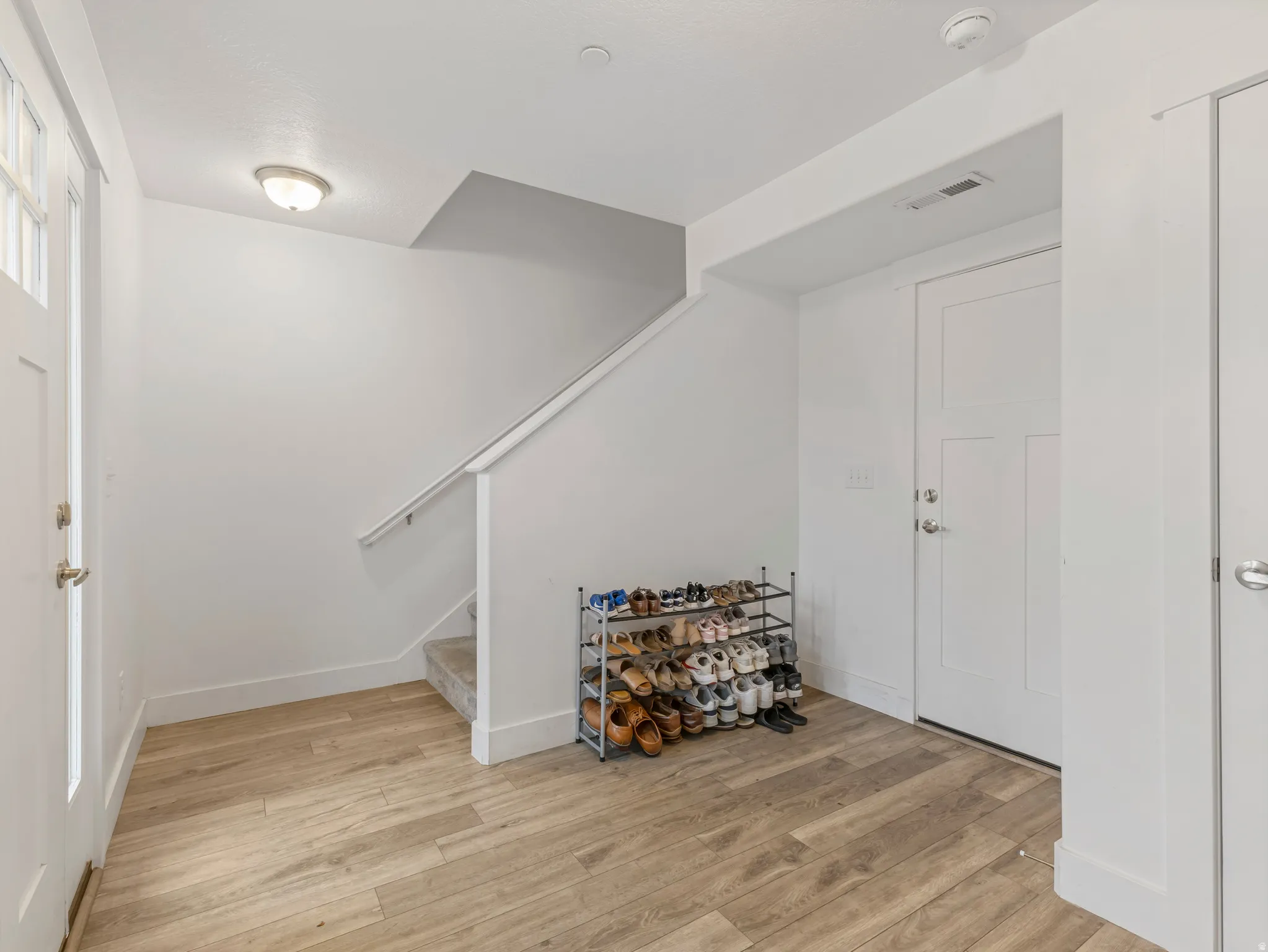 Foyer with light wood-style floors and stairway