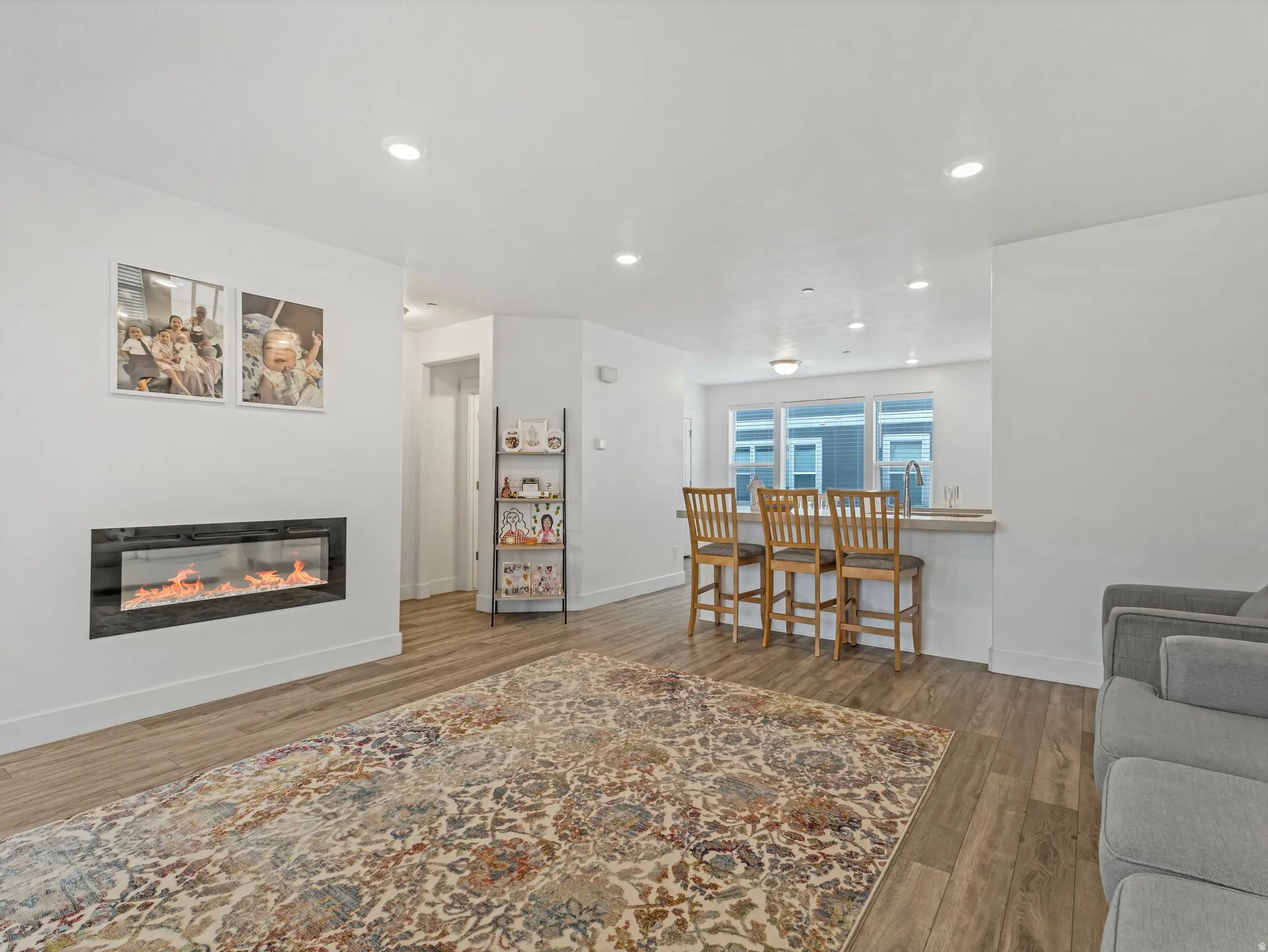 Living area featuring a glass covered fireplace, dark wood-style floors, and recessed lighting