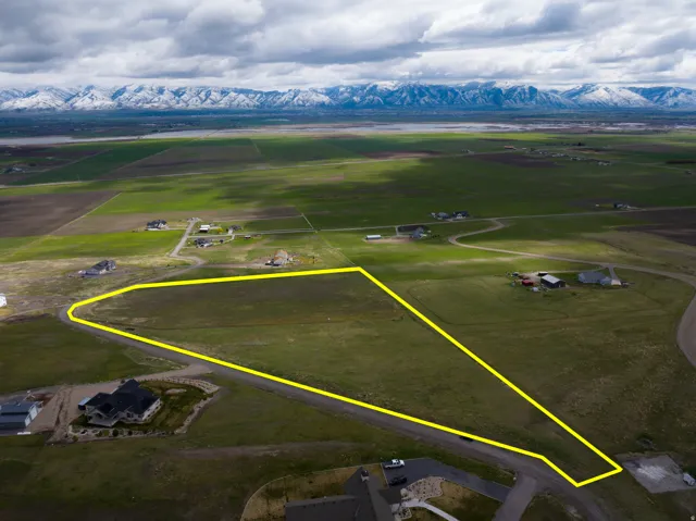 Overview of rural landscape featuring property boundaries highlighted and a mountain backdrop