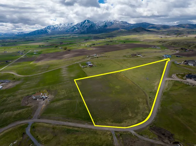 Overview of rural landscape featuring property boundaries highlighted and a mountain backdrop