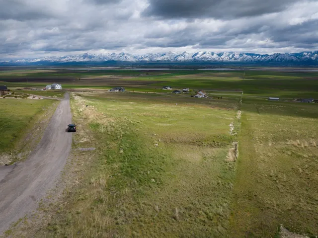 Overview of rural landscape featuring a mountain backdrop and large plots for crops