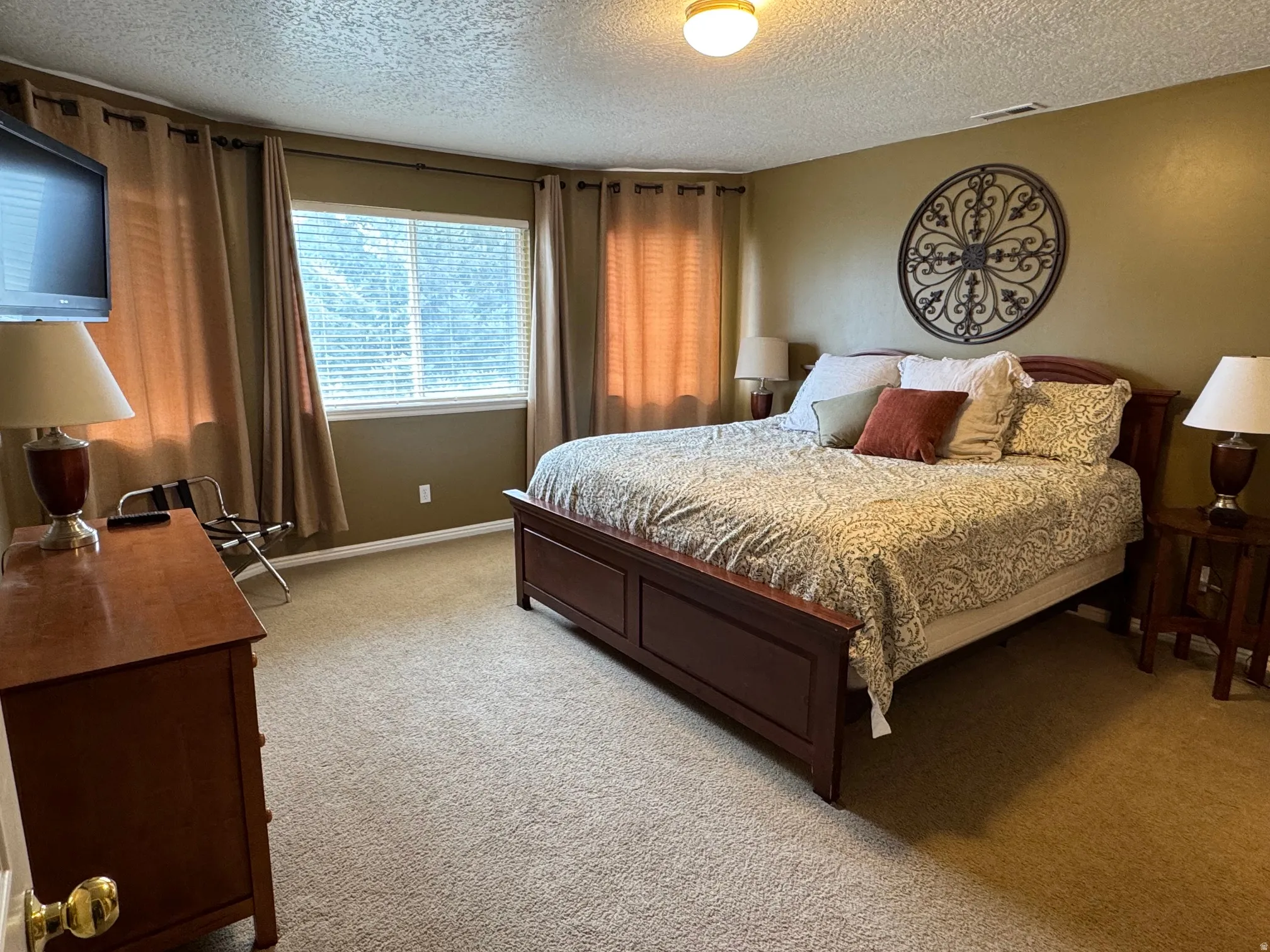 Bedroom featuring a textured ceiling and light colored carpet