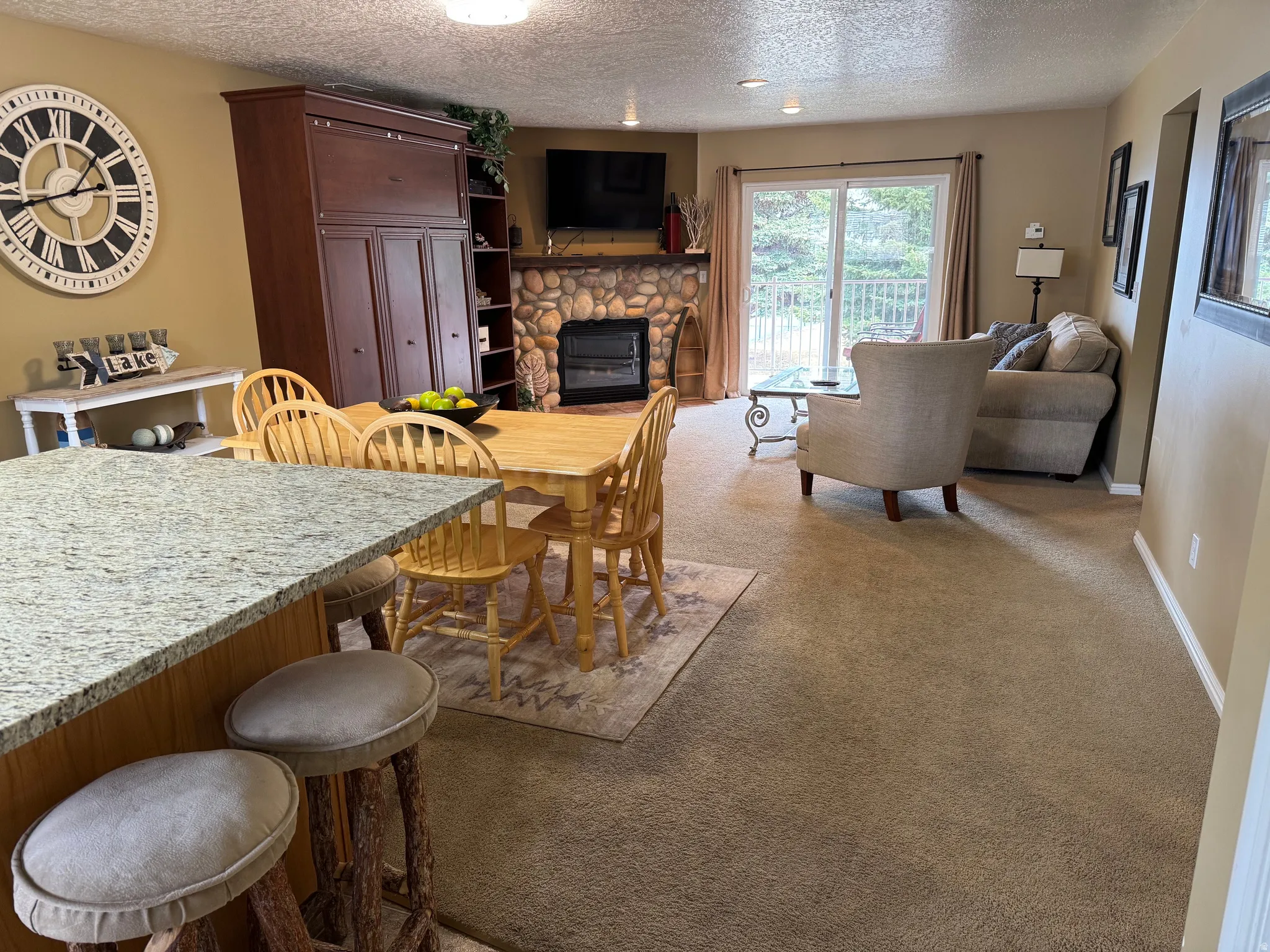 Dining space featuring carpet flooring, a textured ceiling, and a fireplace