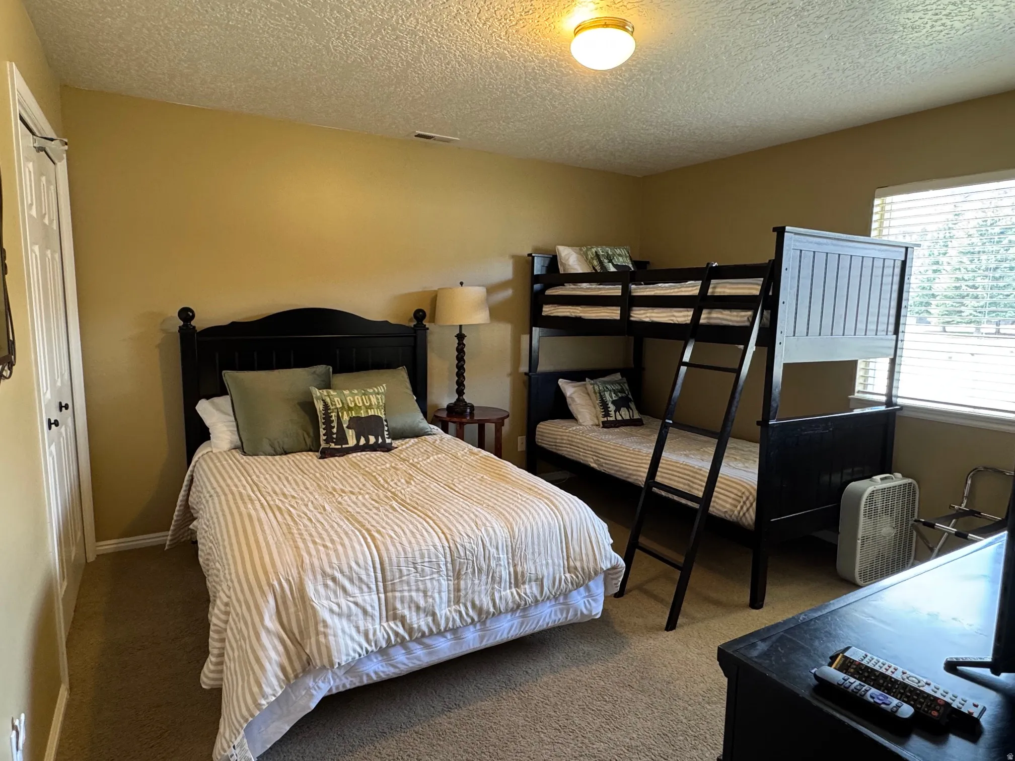 Bedroom featuring carpet, a closet, and a textured ceiling