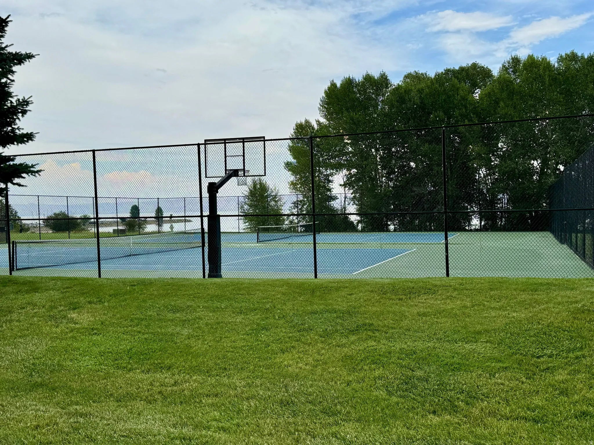 View of tennis court with community basketball court