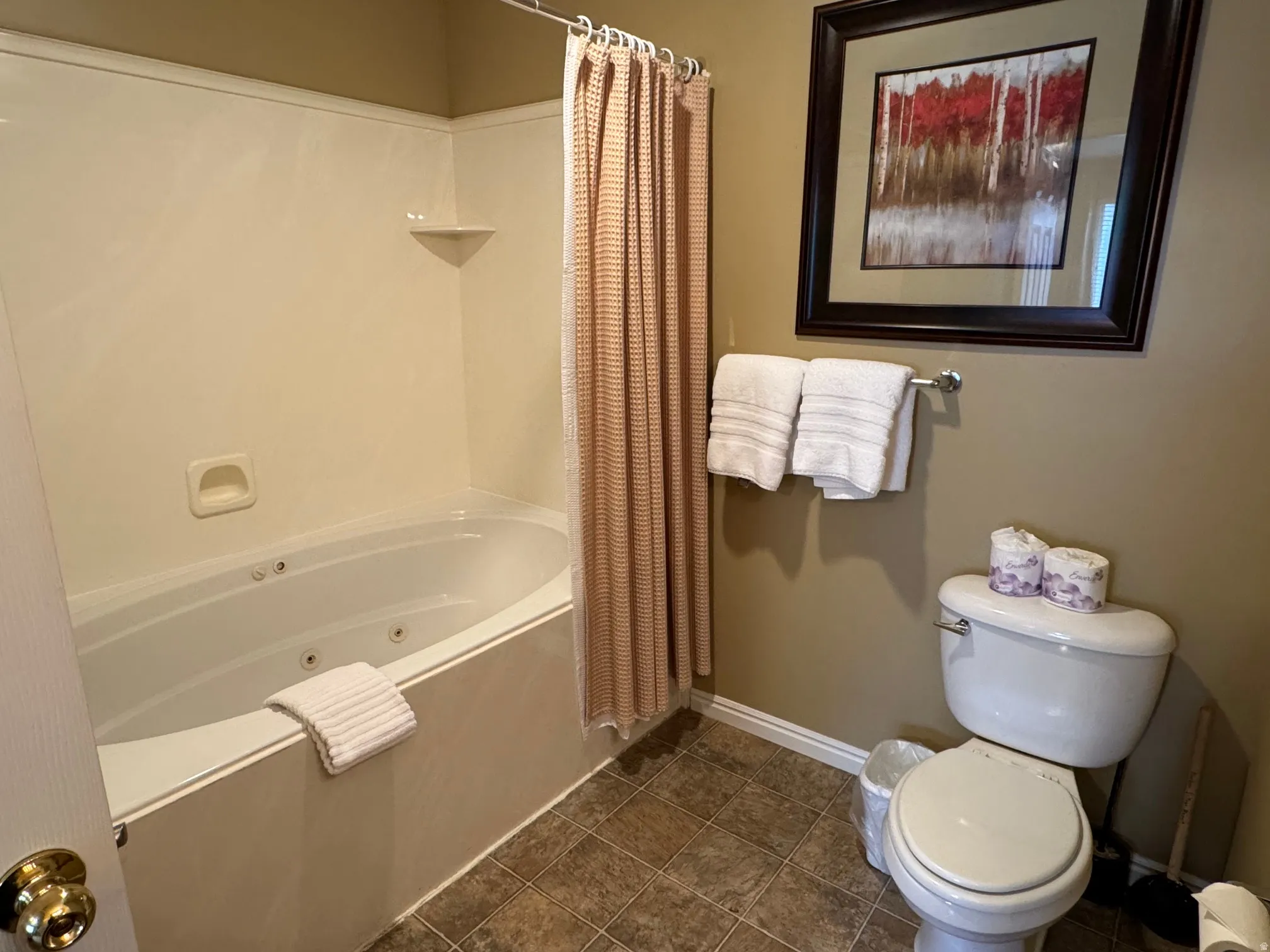 Bathroom with a combined bath / shower with jetted tub and dark tile patterned floors