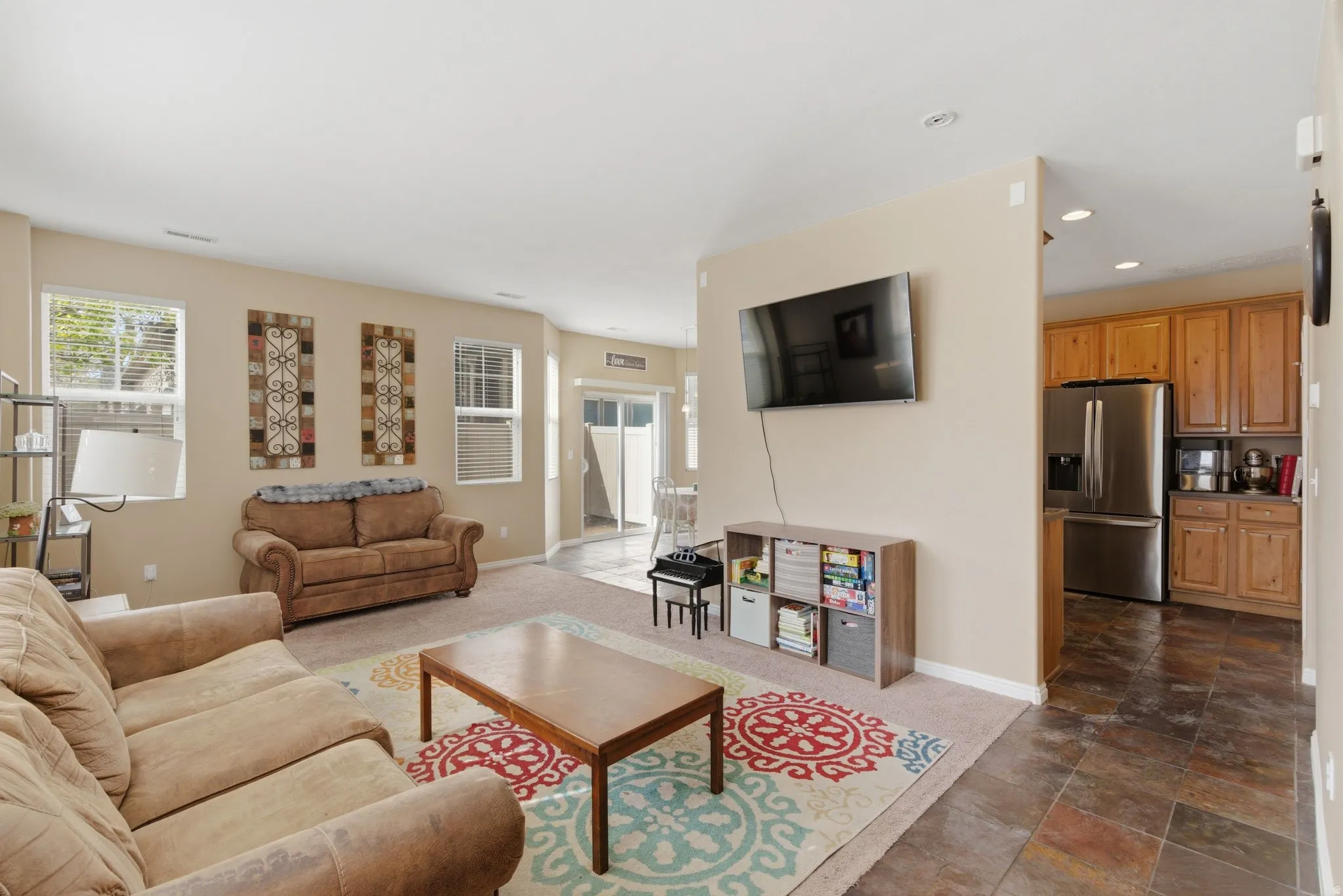 Living area with dark colored carpet, recessed lighting, and dark stone finish flooring