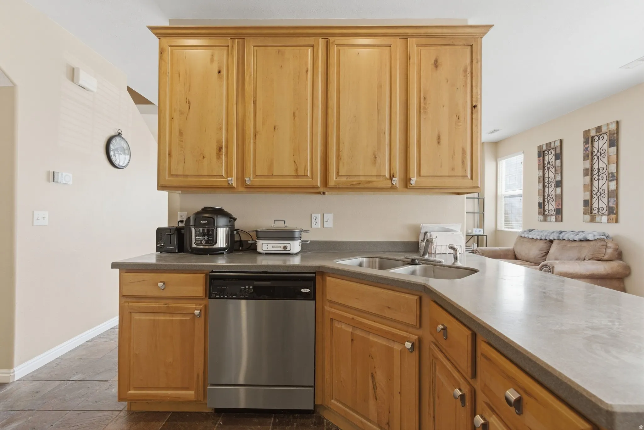 Kitchen with dishwasher, dark countertops, and a peninsula