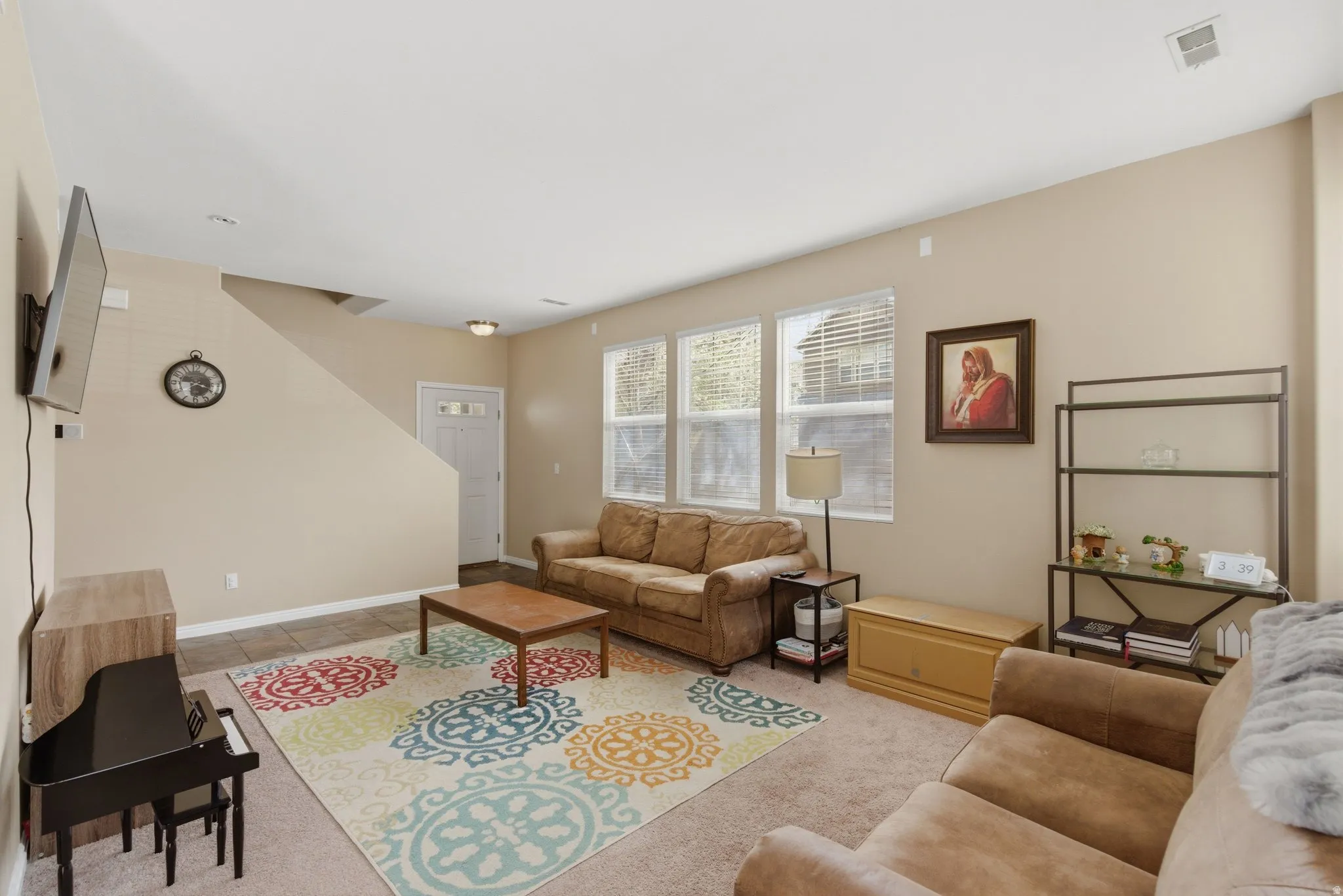 Living room with light colored carpet and baseboards