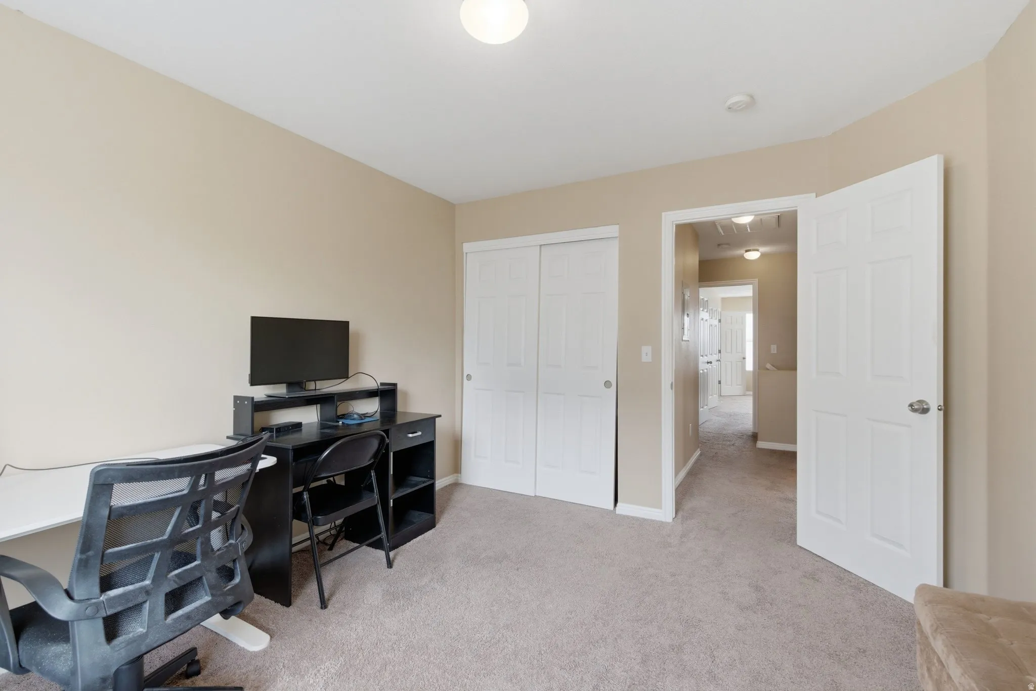 Office space featuring light colored carpet and baseboards