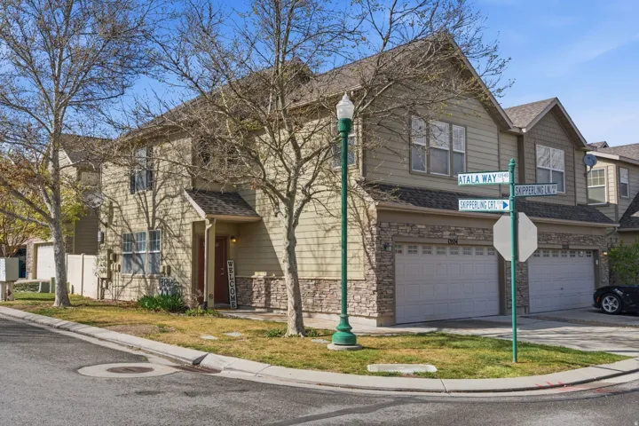 Traditional-style home featuring a garage, stone siding, concrete driveway, and a shingled roof