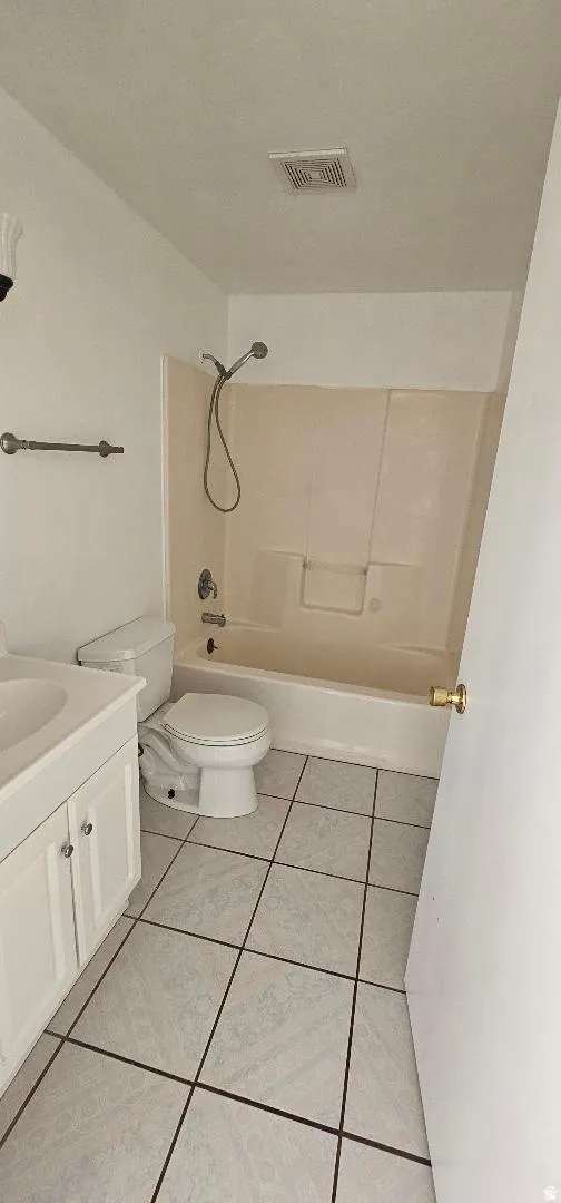 Bathroom featuring vanity,  shower combination, and light tile patterned floors