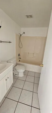 Bathroom featuring vanity,  shower combination, and light tile patterned floors