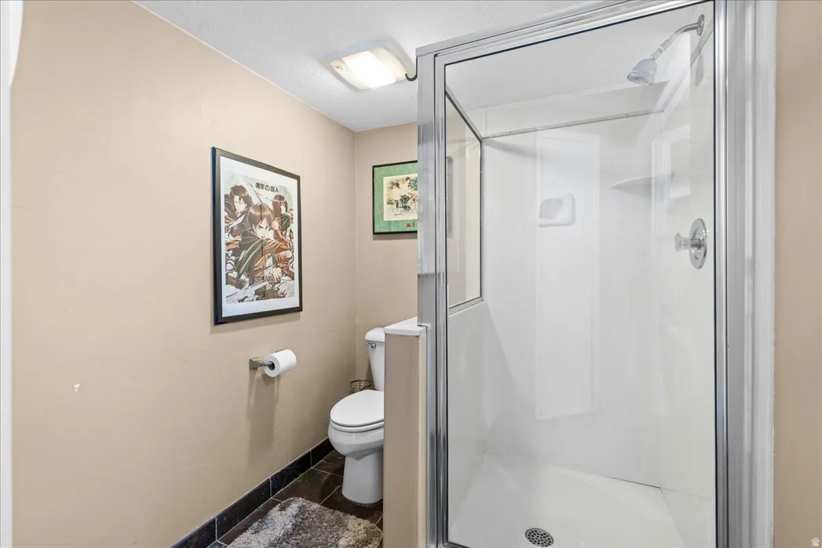 Full bathroom with toilet and a shower stall
