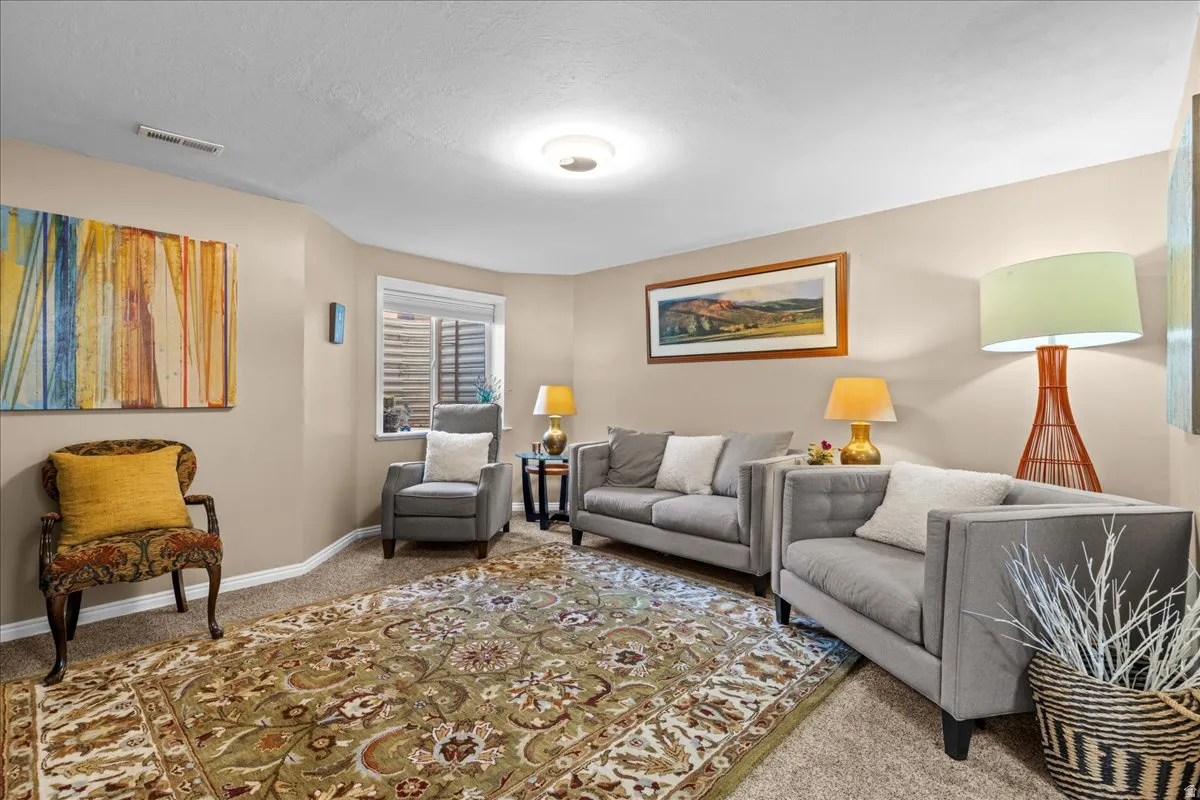 Living area featuring light colored carpet and a textured ceiling