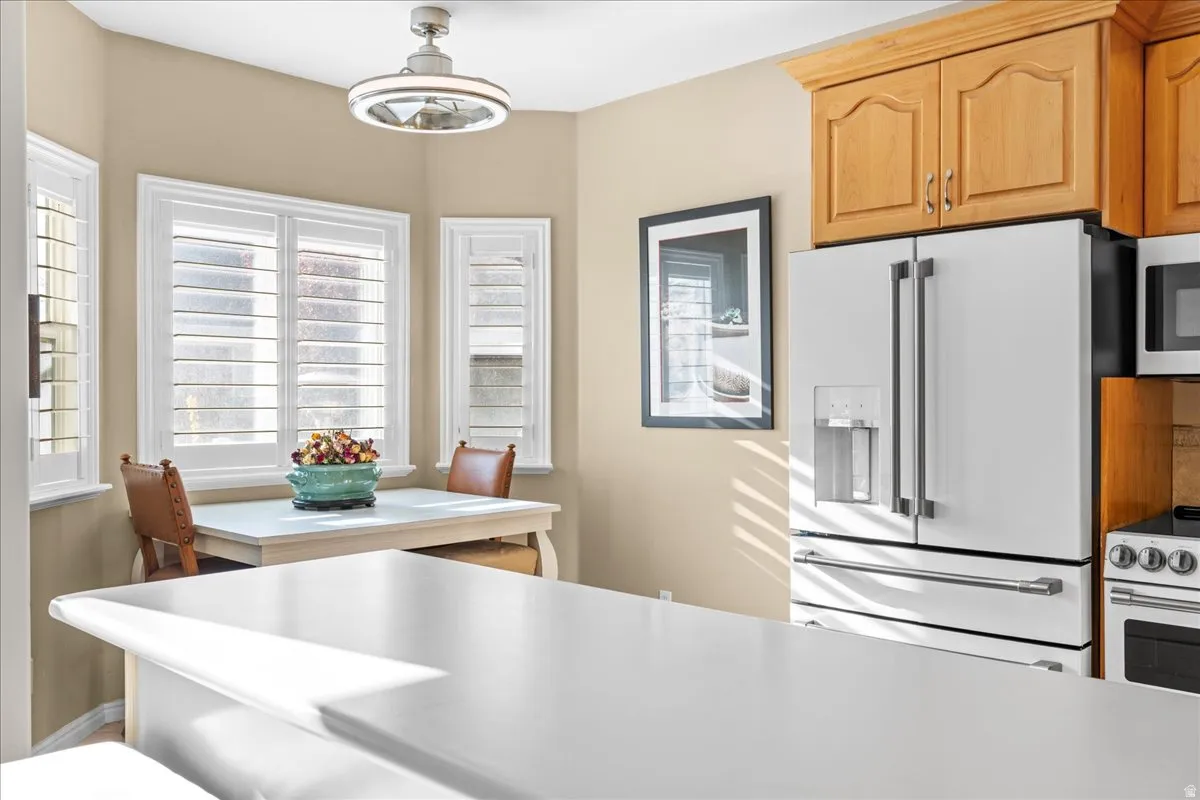 Kitchen featuring white appliances, light countertops, and hanging light fixtures