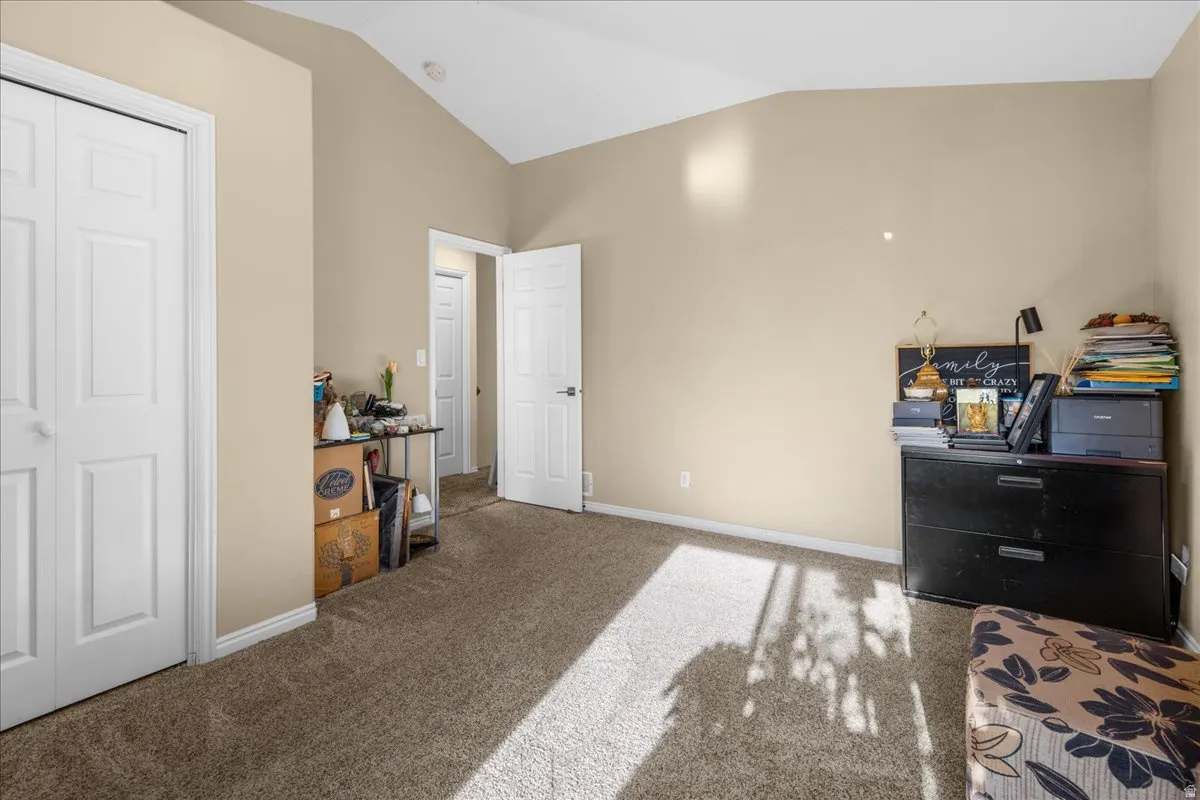Bedroom featuring vaulted ceiling, carpet floors, and a closet