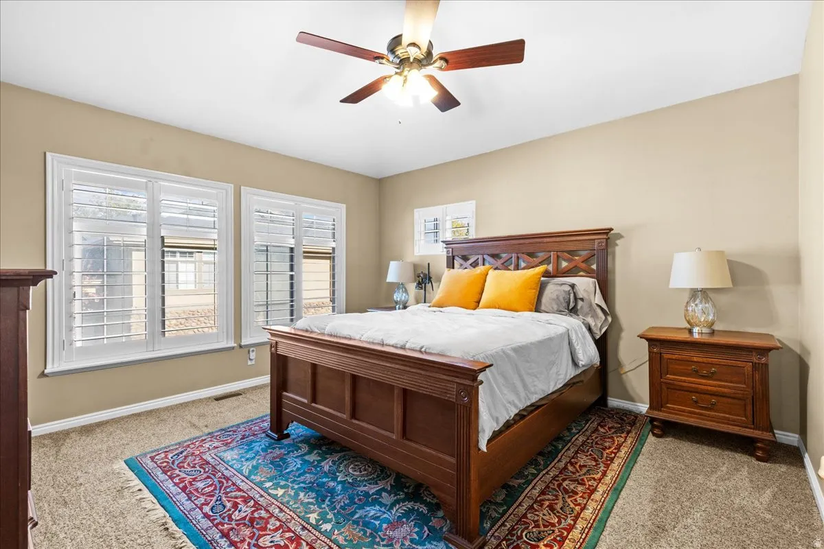 Bedroom with light carpet and ceiling fan
