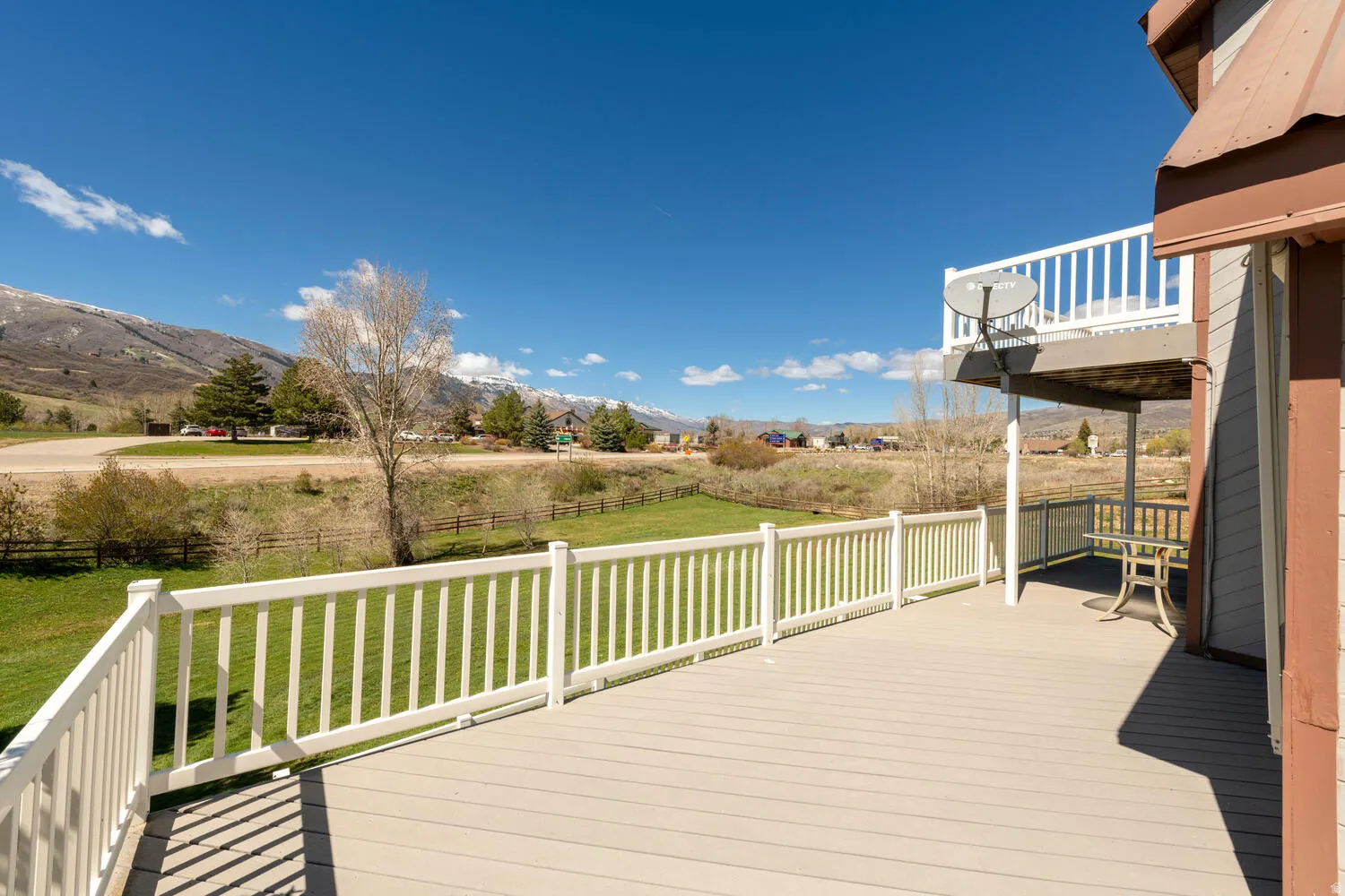 Wooden deck featuring a mountain view and a fenced backyard