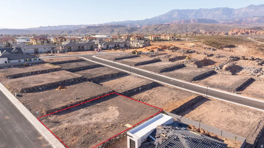 Aerial view of residential area featuring property boundaries highlighted and mountains