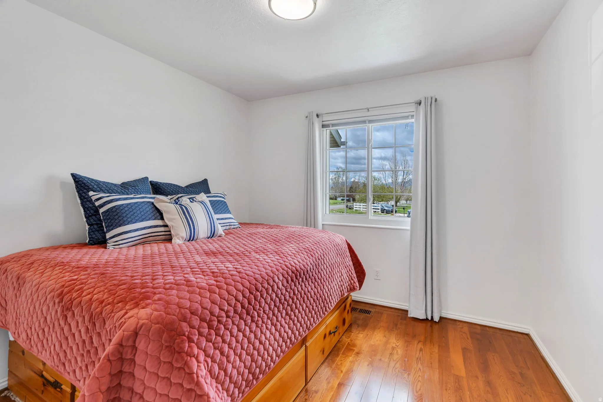 Bedroom with wood-type flooring and baseboards