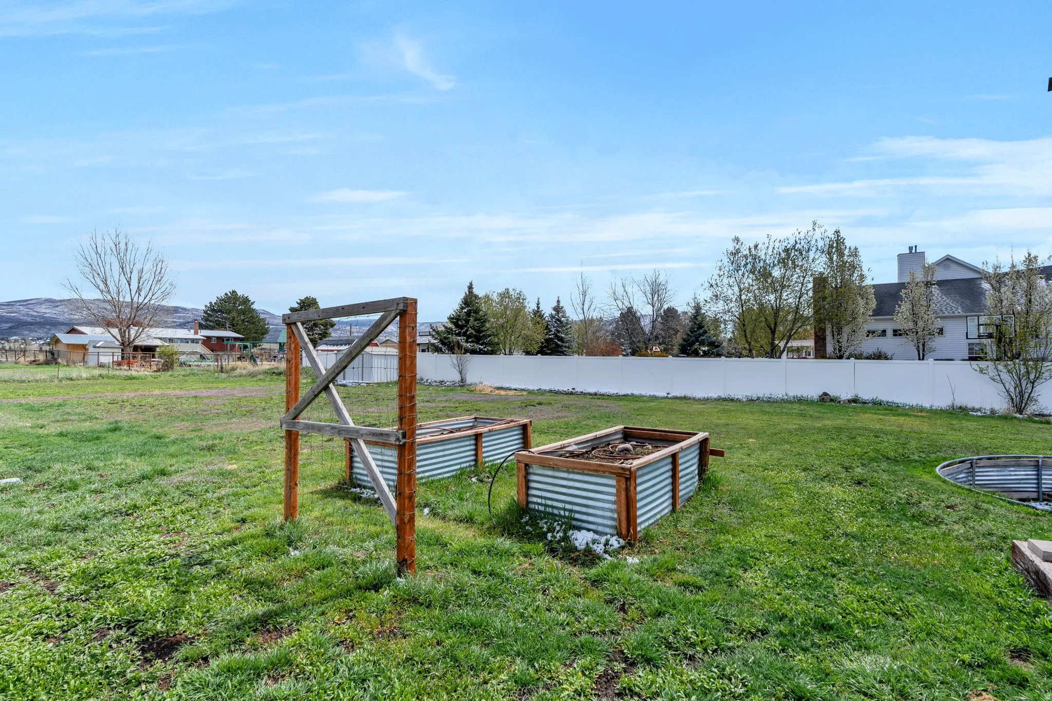 Fenced backyard with a vegetable garden